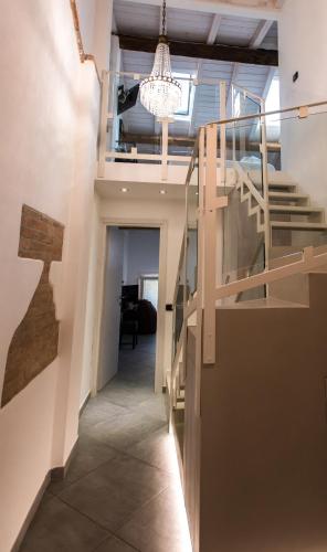 a hallway with a staircase and a chandelier at Luna Sul Tetto in Carpi