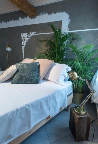 a bedroom with a bed with plants on it at Luna Sul Tetto in Carpi