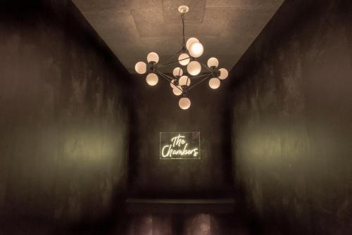 a chandelier in a dark room with a sign at The Chamberlain in London