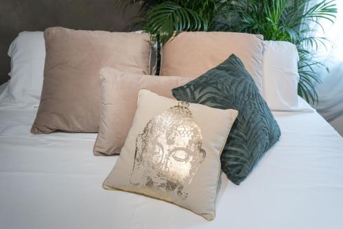a bed with four pillows and a mask on it at Luna Sul Tetto in Carpi