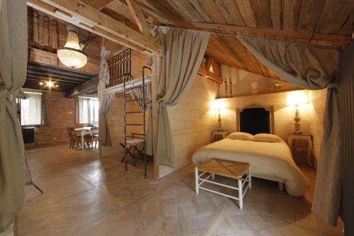 um quarto com uma cama num quarto com tectos em madeira em L'annexe du chateau des Girards em Lans-en-Vercors