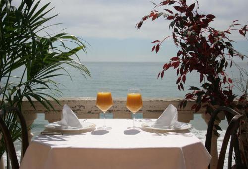 a table with two glasses of wine on the beach at Hotel Badano sul Mare in Alassio