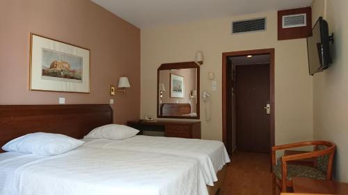 - une chambre d'hôtel avec un lit et un miroir dans l'établissement Economy Hotel, à Athènes