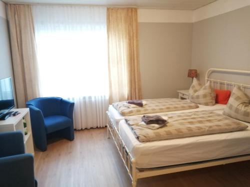 a bedroom with two beds and a chair and a window at Nordfriesisches Haus in Tönning