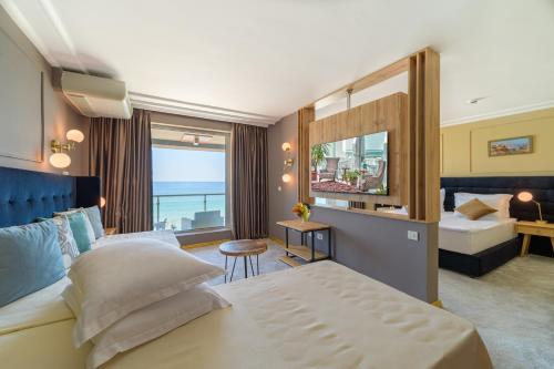 Una habitación de hotel con una cama y una ventana grande. en Marina Hotel, Sunny Day, en Saints Constantine and Helena