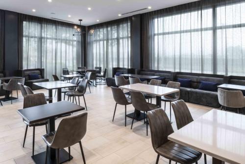 a restaurant with tables and chairs and a couch at Holiday Inn Express - Boston Logan Airport - Revere, an IHG Hotel in Revere