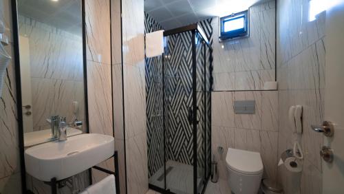 a bathroom with a shower and a sink and a toilet at The Mori Club Hotel in Antalya