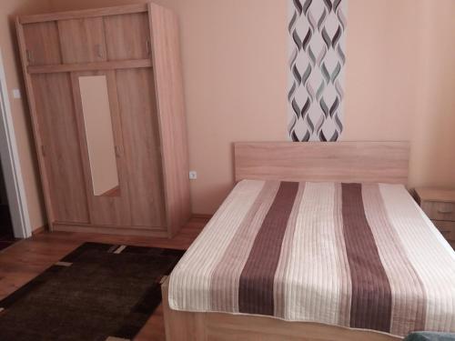 a bedroom with a bed and a wooden door at Ezüstfenyő Vendégház in Sárospatak