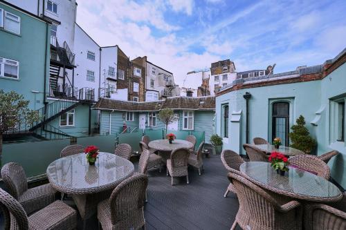 a patio with tables and chairs on a balcony at Hotel Du Vin & Bistro Brighton in Brighton & Hove