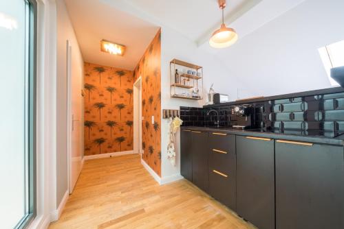 a kitchen with black cabinets and a wooden floor at Design Apartments - "Villa Arnim" in Potsdam