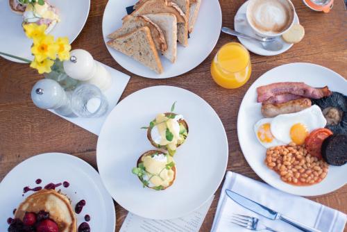 a table topped with plates of breakfast foods and coffee at The Chamberlain in London