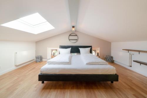 a bedroom with a large bed and a skylight at Design Apartments - "Villa Arnim" in Potsdam
