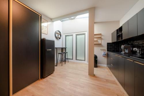 a kitchen with a black refrigerator and a table at Design Apartments - "Villa Arnim" in Potsdam