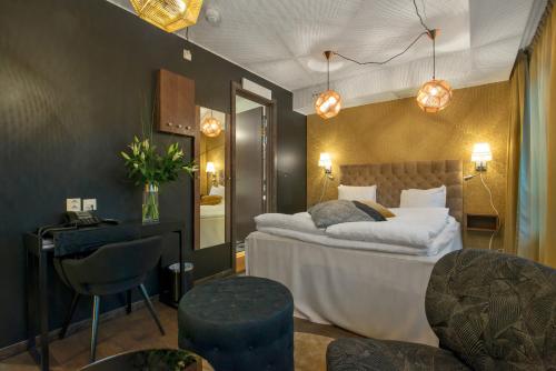 a bedroom with a bed and a desk and chairs at Best Western Hotel Akersberga in Åkersberga