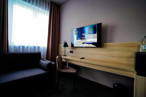 a hotel room with a desk with a television on it at Hotel Viktorosa in Hofgeismar