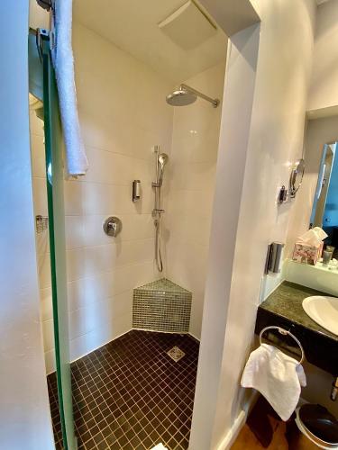 a shower with a glass door in a bathroom at Das Nikolai Hotel in Munich