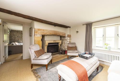 - une chambre avec une cheminée, un lit et des chaises dans l'établissement Manor Farmhouse, à Dorchester