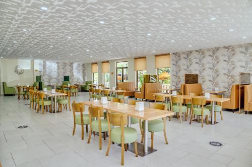 a dining room with wooden tables and chairs at Mirage Hotel in Shekvetili