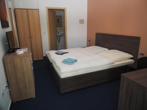a bedroom with a large bed with a wooden headboard at Messe Motel Laatzen in Hannover