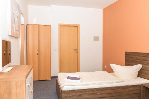 a bedroom with a bed and a wooden cabinet at Messe Motel Laatzen in Hannover