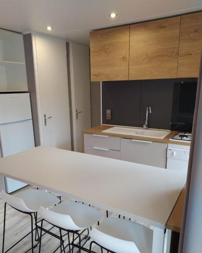 a kitchen with a white table and chairs at Cap Océan in Seignosse