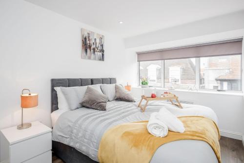 a white bedroom with a large bed and a window at Watford Central Serviced Apartments - F5 in Watford