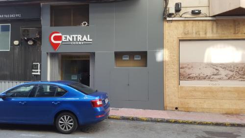 a blue car parked in front of a building at Hotel Central Torrevieja in Torrevieja