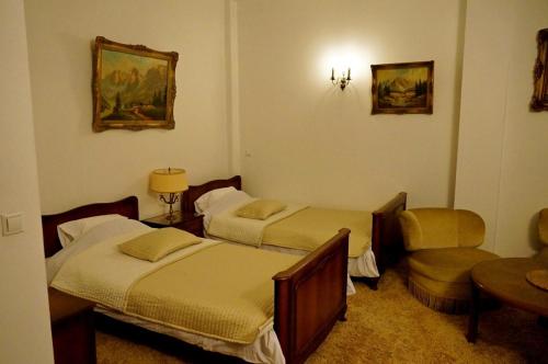 a hotel room with two beds and a chair at Willa Marysin in Maków Podhalański