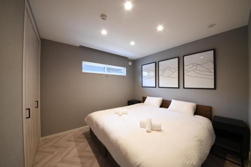 a bedroom with a large bed with two candles on it at Cherrywoods Place by Hakuba White Fox Company in Hakuba