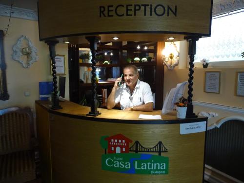 a man talking on a cell phone at a kiosk at Hotel Casa Latina in Budapest