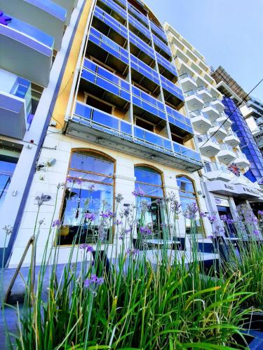 a building with windows and plants in front of it at Hotel Kennedy Nova in Il-Gżira