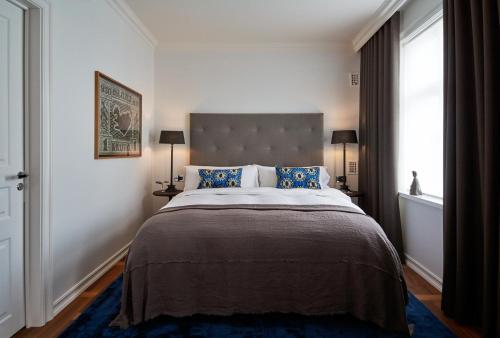 a bedroom with a large bed with a large window at Sand Hotel by Keahotels in Reykjavík