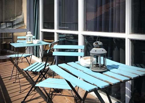 a blue picnic table and two chairs on a porch at Quartier Bilbao Hostel in Bilbao