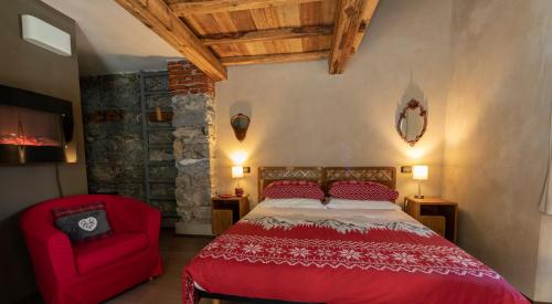 a bedroom with a red bed and a red chair at La Stazione dell'Acqua in Introd