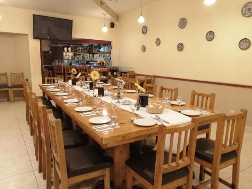 a long wooden table in a restaurant with chairs at Hotel Palace Puebla in Puebla