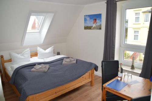 una camera da letto con un letto, un tavolo e una finestra di Hotel Südstrand Amrum a Wittdün