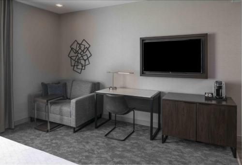a room with a desk and a tv and a chair at Holiday Inn Express - Boston Logan Airport - Revere by IHG in Revere