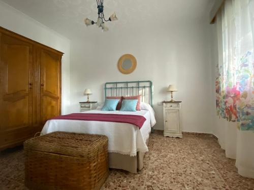 a bedroom with a bed and two tables and a window at El Balcón de la Colgada in Ossa de Montiel
