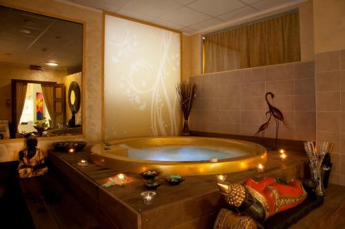 a large bath tub in a bathroom with a large mirror at Hotel Jumbo in Rimini