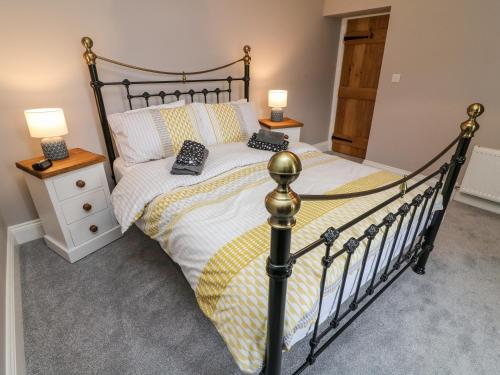 a bedroom with a black bed with yellow and white sheets at White Lea in Richmond