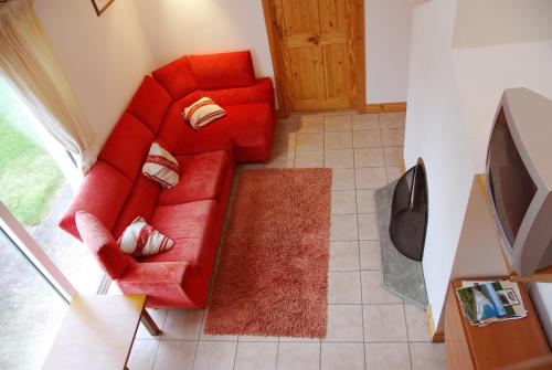 una vista aérea de un sofá rojo en la sala de estar en Burren Way Cottages, en Ballyvaughan