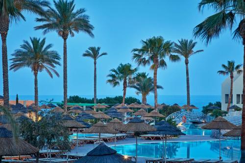 a view of the pool at the resort with palm trees at Atlantica Aegean Blue in Kolimbia