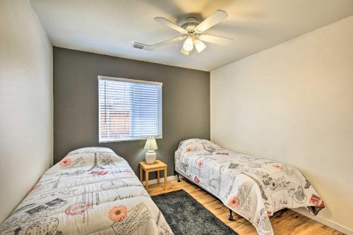 two beds in a bedroom with a ceiling fan at Coachella Retreat Pool, Near Music Festivals in Coachella