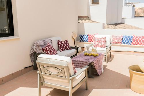 - un ensemble de chaises et d'une table sur une terrasse dans l'établissement Pasaje Zamora Apartamentos, à Séville