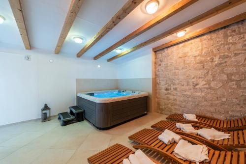 a large room with a hot tub and chairs in it at Heritage Hotel Maskovica Han in Pakoštane