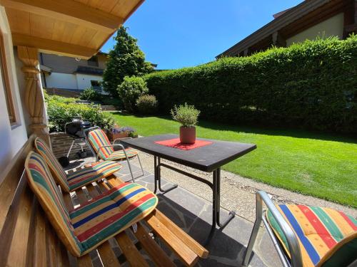 a patio with chairs and a table with a potted plant at Gartenwohnung an der Familienabfahrt in Brixen im Thale