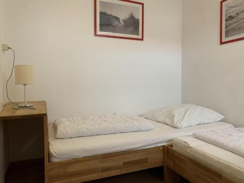 a bedroom with two beds and a table with a lamp at Haus am Deich Wohnung 2 in Dahme