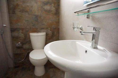 a bathroom with a white sink and a toilet at Melisma 189, Nawajanapadaya, RuwanEliya,NuwaraEliya in Nuwara Eliya