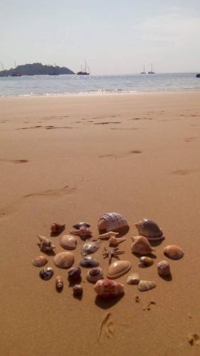 a group of rocks in the sand on a beach at Baan Suan Kayoo 2 Buffalo Bay Aow Khao Kwai in Ko Phayam