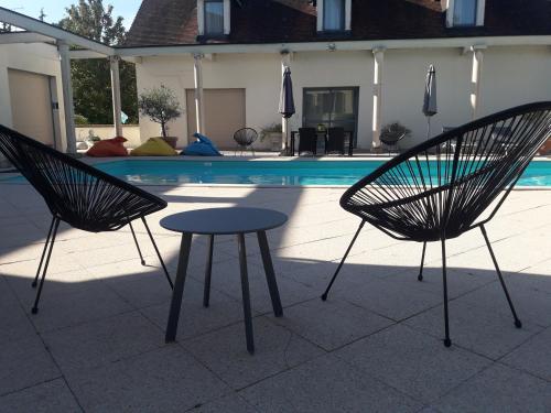two chairs and a table in front of a pool at Hotel Pinocchio in Gy